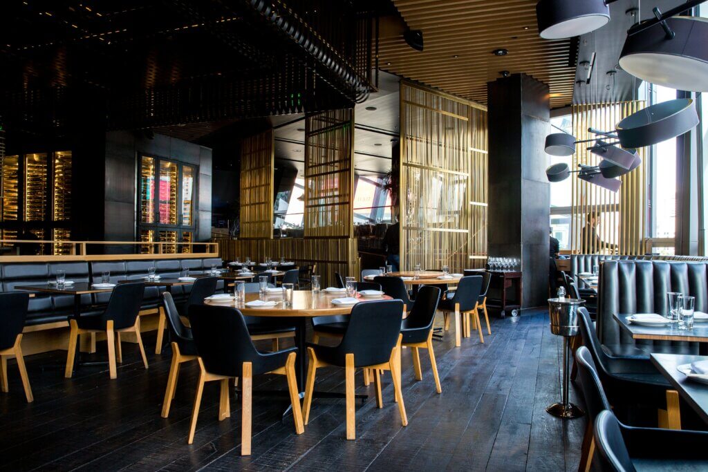 Empty Restaurant Dining Room with Stylish Black Leather Seats and Wooden Floor