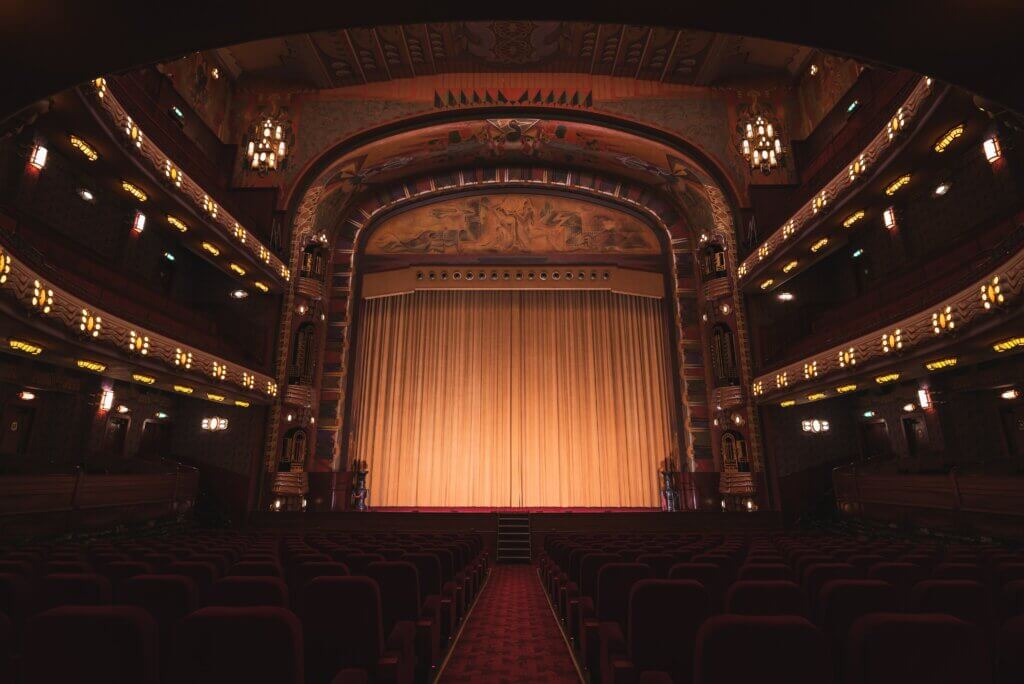 an old theatre with the curtain drawn and lights dimmed