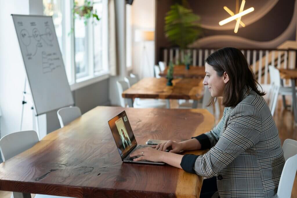 woman sitting on her laptop on a video call with a client