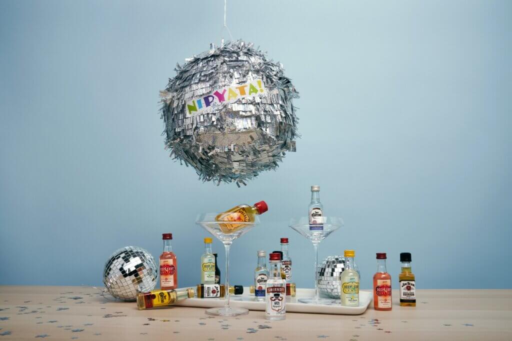 A table with spirits, disco balls, and martini glasses on it, along with a disco ball at the top