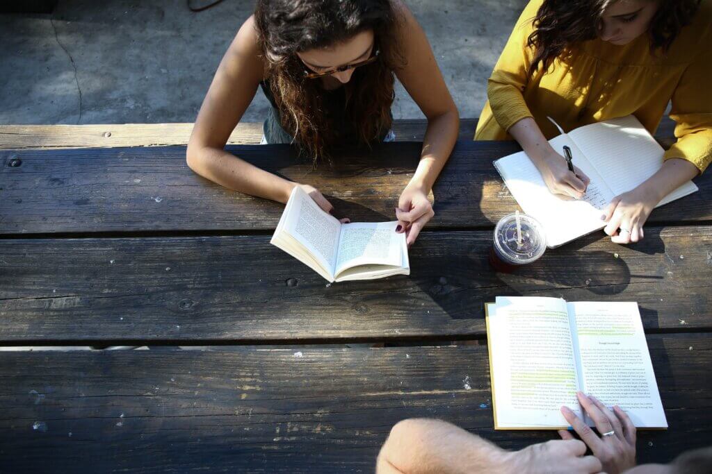 Three Girls Studying Together at an Outdoor Table