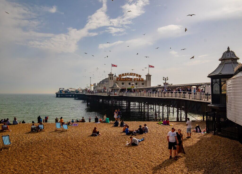 Brighton Pier and Brighton Beach on a sunny day with seagulls flying