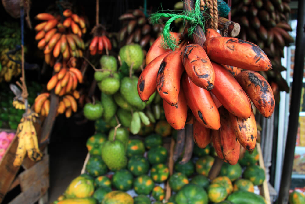 International fruits and vegetables hanging up in a market stall