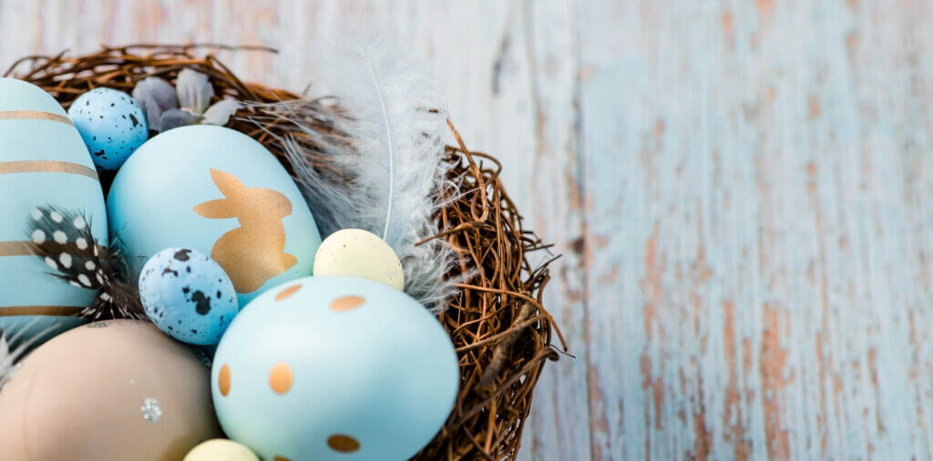 A nest with blue hand-painted easter eggs