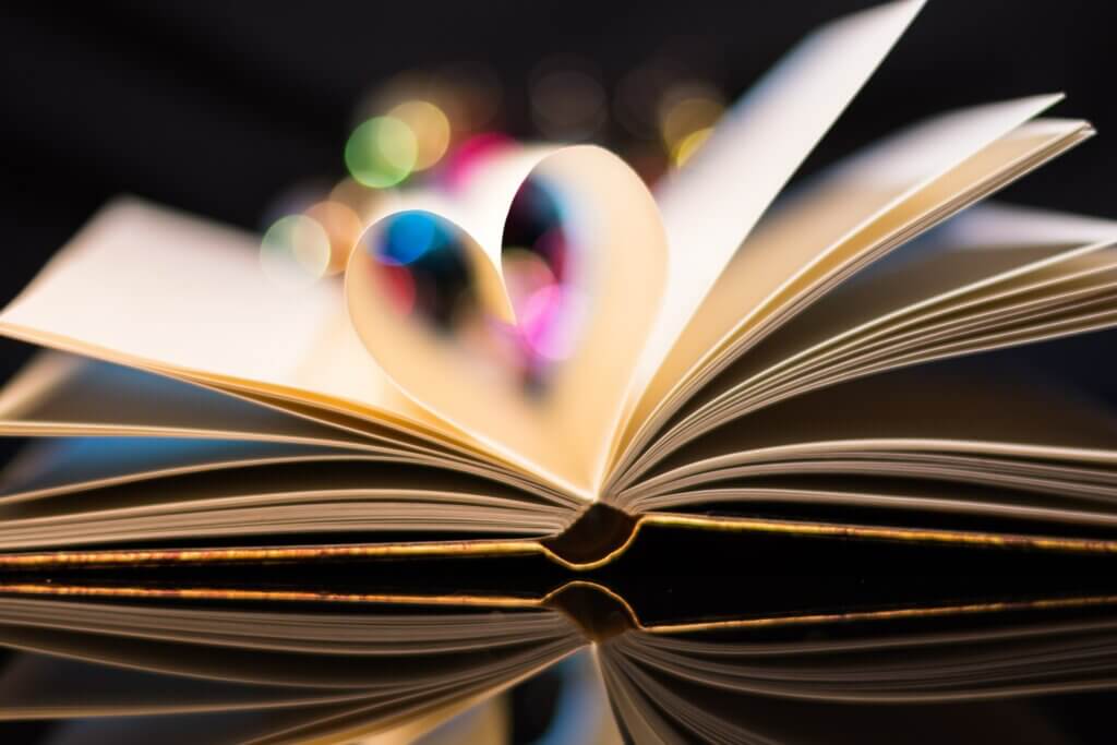 An open book with two pages folded to create the shape of a heart