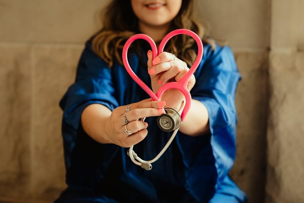 Nurse holding stethoscope and folding the wire into a heart shape