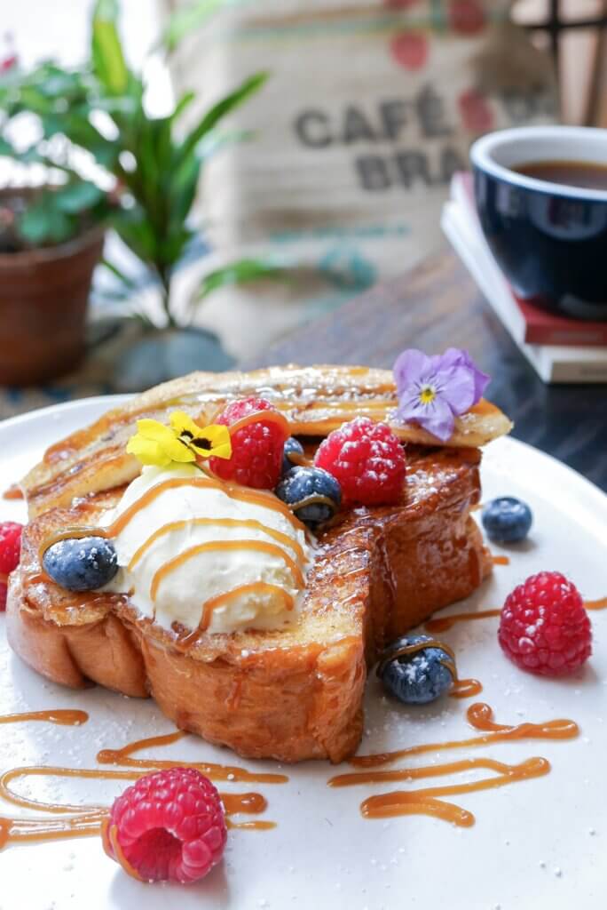 French toast served at a restaurant with berries and ice cream
