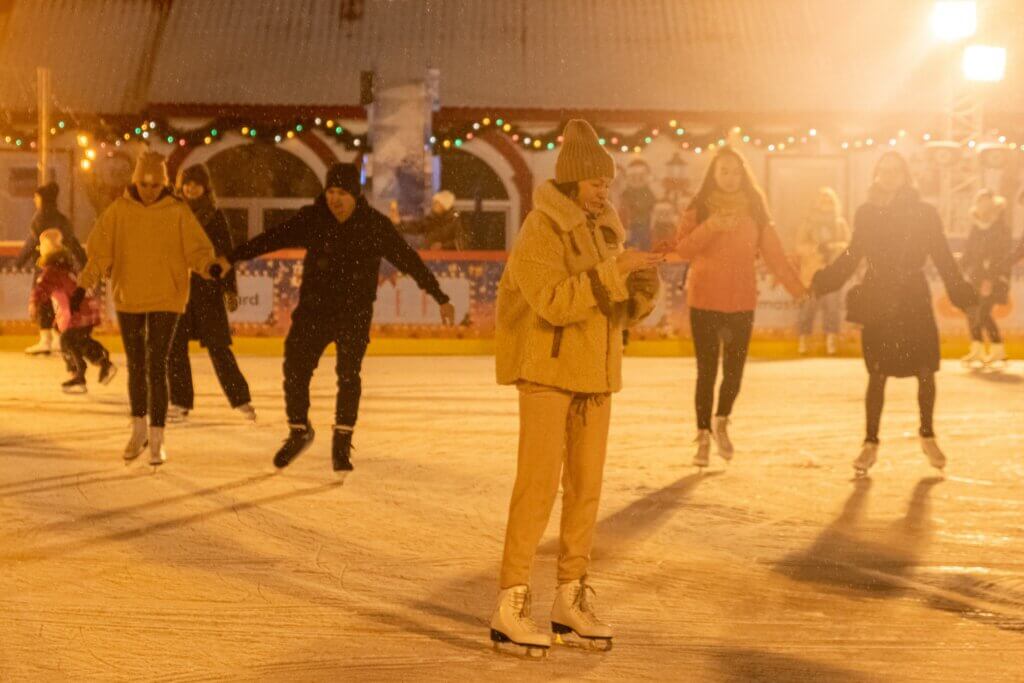 People ice skating in the dark at Christmas time