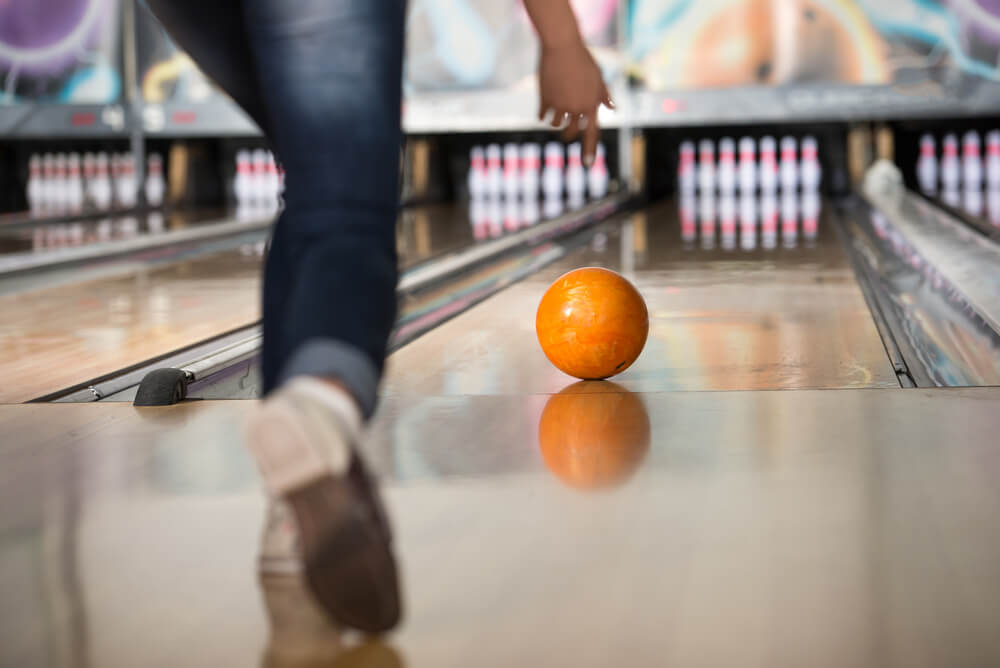 Someone Bowling with an orange ball
