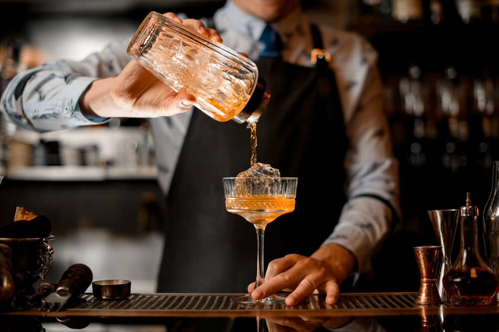Someone pouring cocktails and one of the best East London bars